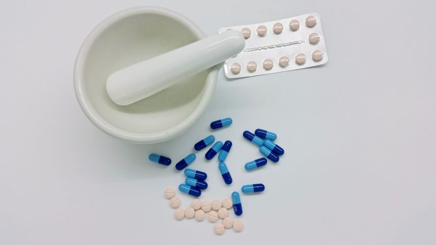 A pharmacist uses a mortar and pestle to compound medication Compounding